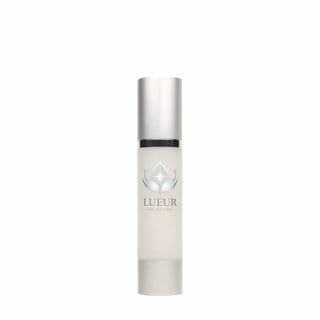 LUEUR skincare serum in white cylindrical bottle with silver metallic cap and lotus logo label