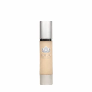 Luftur skincare serum bottle with metallic silver cap and beige liquid, featuring a lotus flower logo